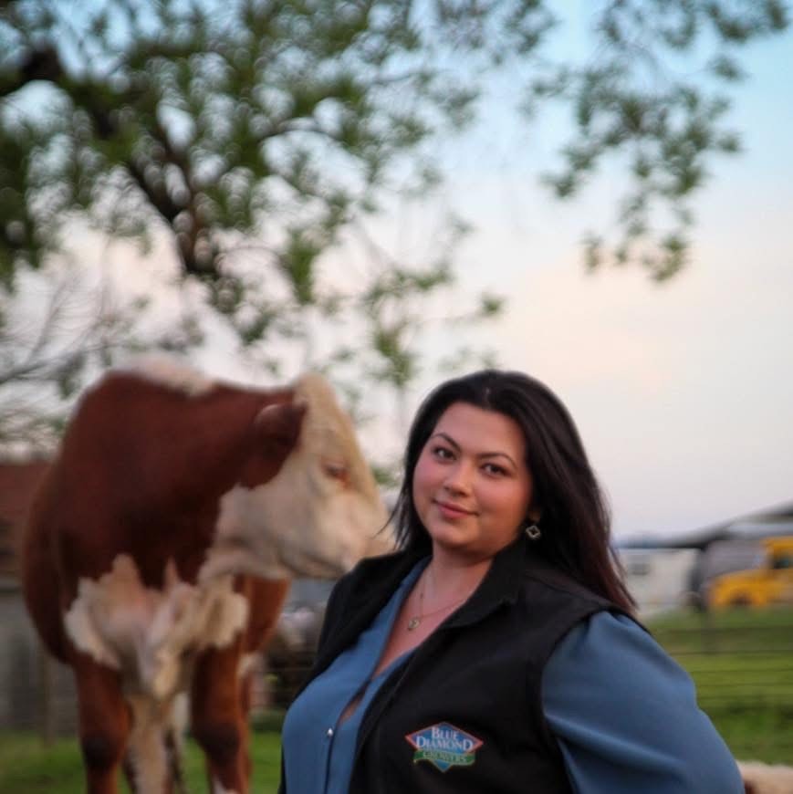Lyndsey Burcina in front of a cow outdoors in nature