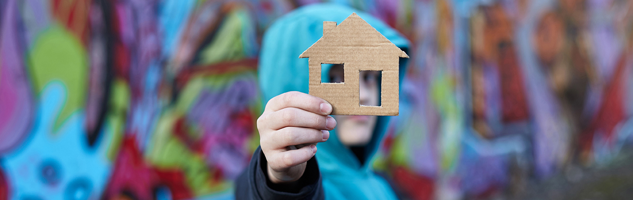 child holding cutout of house