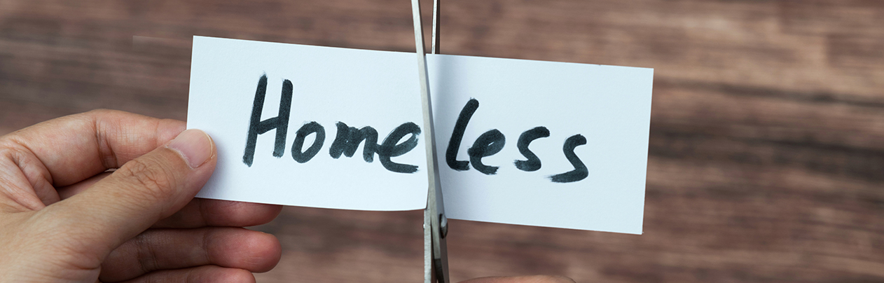 scissors cutting homeless word on paper