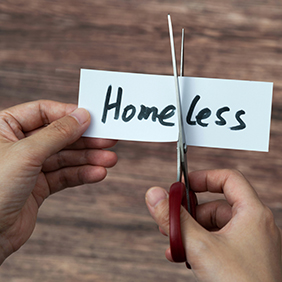 scissors cutting homeless word on paper