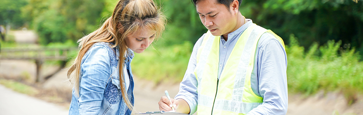 two people outdoors with a clipboard 